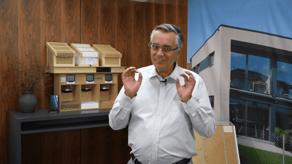 Peter Wolff erklärt den Hitzeschutz im Holzhaus anhand von drei Dämmstoff-Testmodellen.